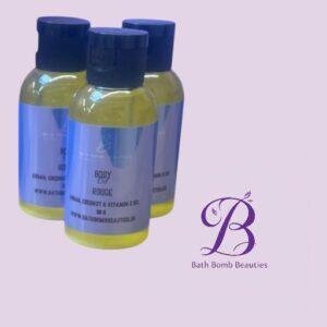 Three yellow bath product bottles with dark blue caps on a light purple background with a bath bomb beauties logo in the corner at right