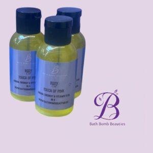 Three yellow bottles with dark blue caps labeled body and touch of pink beside a purple bath bomb beauties logo on a lavender background
