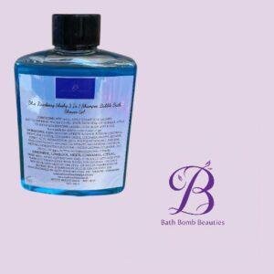 Blue bottle with black cap on a light lavender background, label text visible beside the Bath Bomb Beauties logo.