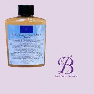 Amber bottle with a black cap and blue label, placed on a light lavender background beside a purple Bath Bomb Beauties logo.