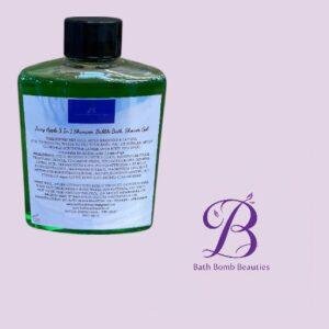 Green bottle with a black cap containing a Bath Bomb Beauties bath product, set against a pastel purple background with a purple logo on the right.