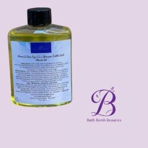 Clear square bottle of yellow shower gel with a black cap and a white label, placed next to a purple Bath Bomb Beauties logo.