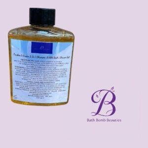 Amber bottle of Bath Bomb Beauties shampoo/shower gel with a blue label, placed on a pale purple background beside the brand logo.