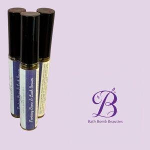 Three lip balm tubes with black caps standing upright on a lavender background, Bath Bomb Beauties branding visible bottom right.