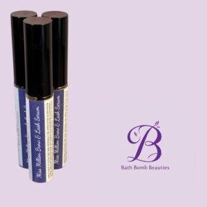Three black-capped cosmetic tubes with blue and white labels, arranged on a lavender background beside a Bath Bomb Beauties logo.