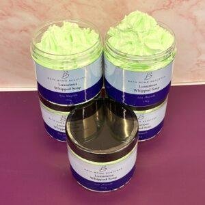 Three jars of luxurious whipped soap with lime green whipped soap on a purple surface labeled bath bomb beauties  ana abiyedh scent  g