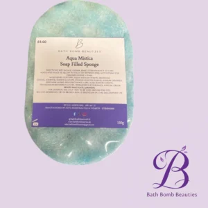 Oval aqua bath sponge with a white label reading Aqua Mistica Soap Filled Sponge; purple Bath Bomb Beauties logo on a lilac background.