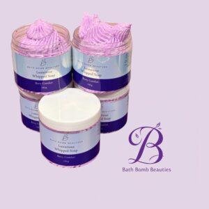 Two glass jars of pink lavender whipped soap from Bath Bomb Beauties, set against a lilac background with visible product labels.