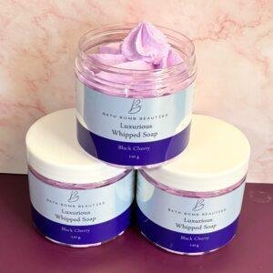 Open jar of Luxurious Whipped Soap in light pink, Black Cherry scent, by Bath Bomb Beautities, sitting on two sealed jars.
