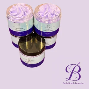 Two clear jars filled with lavender whipped soap (Bath Bomb Beauties Luxurious Whipped Soap, Black Opium scent) against a pastel purple background.