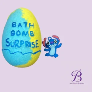 Blue and yellow bath bomb with the words bath bomb surprise and a cute blue cartoon creature beside it on a lavender background