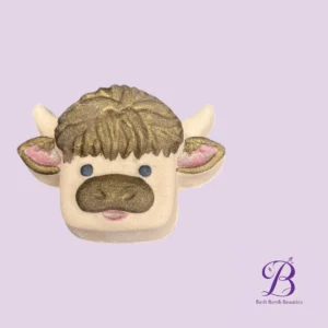 Cute cow shaped bath bomb with glittery brown hair blue eyes pink ears on a soft lavender background bath bomb beauties