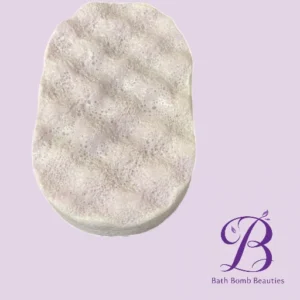 Oval white bath bomb with a bubbly surface on a pale lavender background; Bath Bomb Beauties logo in purple in the bottom-right corner.