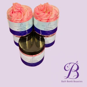Two pink whipped soaps in clear jars labeled Bath Bomb Beauties Luxurious Whipped Soap Fakher Rose, set against a lavender background.