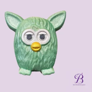 Top half of a glittery green owl shaped bath bomb figure against a lavender background with bath bomb beauties logo in the bottom right