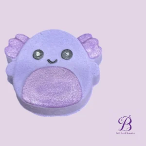 Cute purple bath-bomb shaped creature with glittery pink belly and wings, smiling, on a lavender background with Bath Bomb Beauties logo.