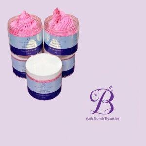 Two pink whipped soap jars with blue labels on a lavender background. The right jar shows product name 'Luxurious Whipped Soap'.