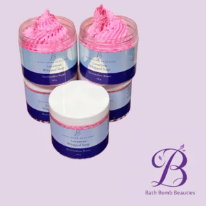 Two pink whipped soap jars with blue labels from Bath Bomb Beauties, set against a lavender background.