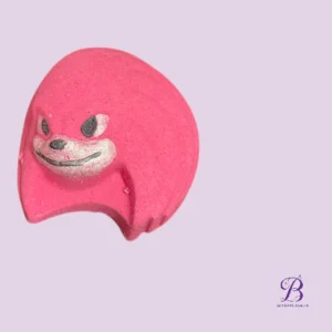 Pink cartoonish eraser with a smiling face on a light purple background, logo bottom-right.