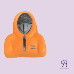 Orange hoodie-shaped bath bomb with a dark masked face on a lavender background; Bath Bomb Beauties logo in the corner.