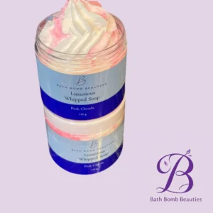 Two stacked jars of Bath Bomb Beauties Luxury Whipped Soap in Pink Clouds, topped with pink–white swirl and a lavender background with logo in corner.