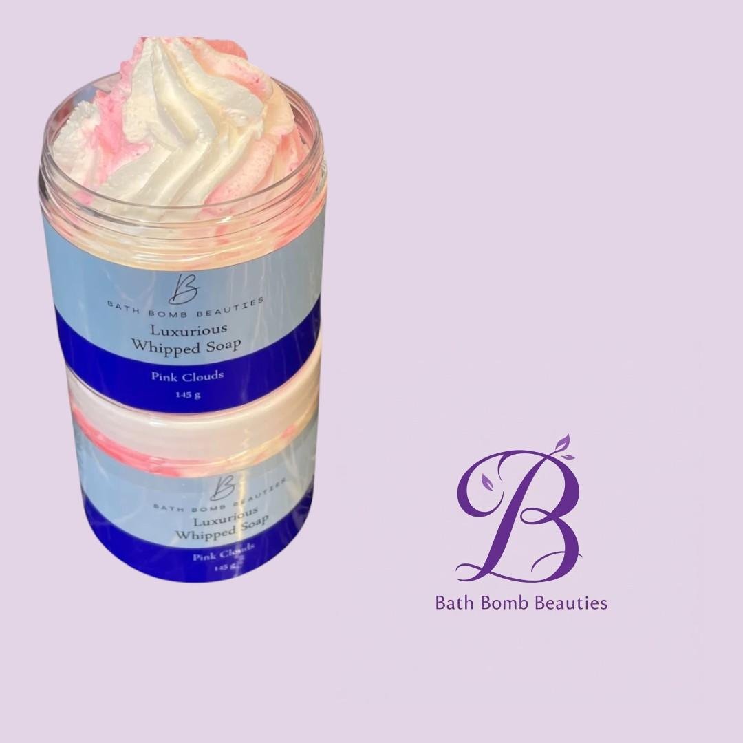 Pink clouds whipped soap bath bomb beauties Jar of luxurious whipped soap with pink cloud foam labeled bath bomb beauties on a lavender background