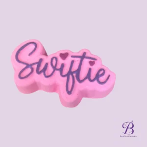 Pink soap shaped like a blob with the cursive word 'Sweetie' in dark purple and small heart accents.