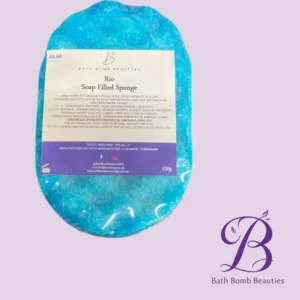 Blue soap-filled sponge with a white label reading 'Rio Soap Filled Sponge' from Bath Bomb Beauties, 150g, on a lavender background.