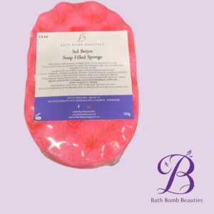 Pink soap filled sponge bath bomb with sol beijos soap filled sponge label on a lavender background