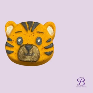 Tiger-faced orange bath bomb with black stripes on a lavender background.