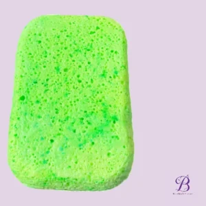 Bright green rectangular kitchen sponge with a porous surface on a pale purple background