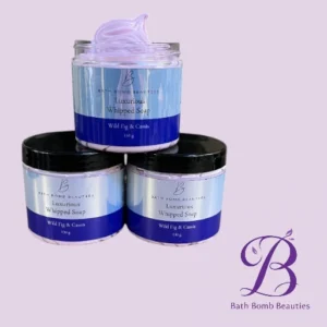 Three Bath Bomb Beauties jars of luxurious whipped soap in blue and white, Wild Fig & Cassis scent, arranged on a pale lavender background with the Bath Bomb Beauties logo in the corner.