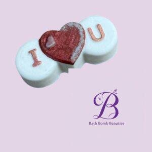 Three white round pills arranged with a red heart in the center forming i love you on a lavender background