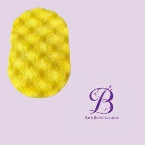 Bright yellow textured bath bomb on a pale lavender background with a purple bath bomb beauties logo in the corner