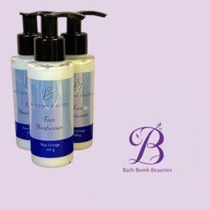 Three bath bomb beauties face moisturiser bottles with pump tops on a lavender background front bottle showing label and blue band  g