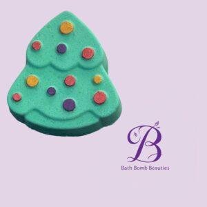 Tree-shaped turquoise bath bomb with multicolored dots on a lavender background, branding shows Bath Bomb Beauties logo in the corner.