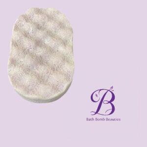 Round, textured white bath bomb on a pastel lavender background, with a purple 'Bath Bomb Beauties' logo nearby.