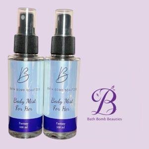 Two light blue body mist bottles labeled body mist for her by bath bomb beauties with a purple logo on lavender background