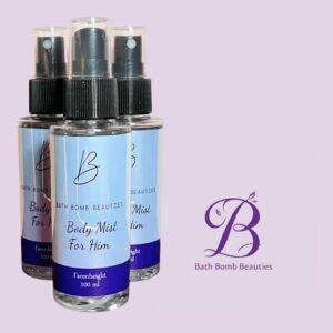 Three bath bomb beauties body mist for him spray bottles with blue labels placed against a pastel purple background with a cursive logo on the right