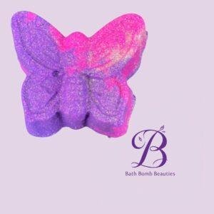 Butterfly-shaped bath bomb in purple and pink glitter on a pale lavender background, with Bath Bomb Beauties logo.