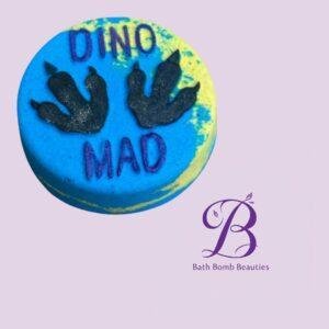 Blue round bath bomb with black dinosaur handprint designs and the text 'DINO MAD'.