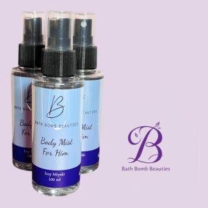 Three bath bomb beauties spray bottles labeled body mist for him arranged on a lavender background with the logo visible in the corner