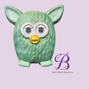 Partial green owl statue against a lavender background, with the Bath Bomb Beauties logo visible in purple script.