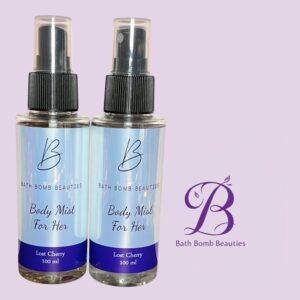 Two spray bottles with blue gradient labels reading body mist for her and lost cherry on a lavender background bath bomb beauties branding nearby
