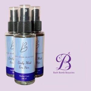 Three bath bomb beauties body mist spray bottles labeled madam coco arranged upright on a lavender background with a purple b logo to the right