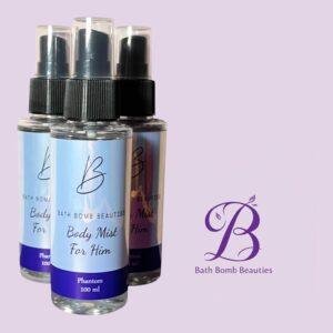 Three bath bomb beauties body mist spray bottles labeled for him on a pastel purple background with the brand logo nearby