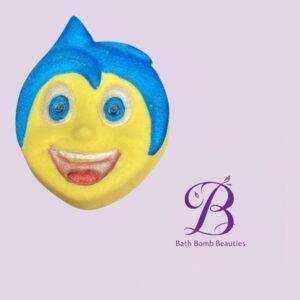 Smiling yellow bath bomb with blue hair on a lavender background featuring a purple bath bomb beauties logo