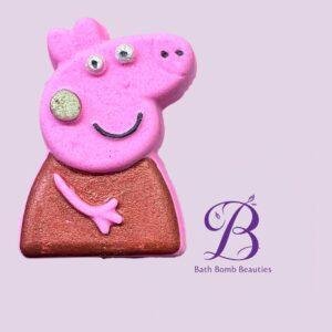 Smiling pink pig shaped bath bomb with glittery body on a lavender background bath bomb beauties logo visible