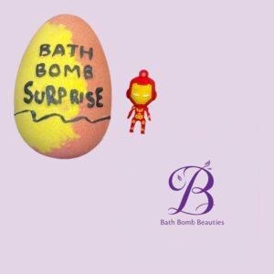 Bath bomb with bath bomb surprise text and a small iron man figure on a lavender background