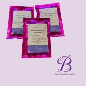Three pink foil packets of Bath Bomb Beauties Deep Conditioning Hair Mask Lost Cherry on a lavender background with logo in the corner.